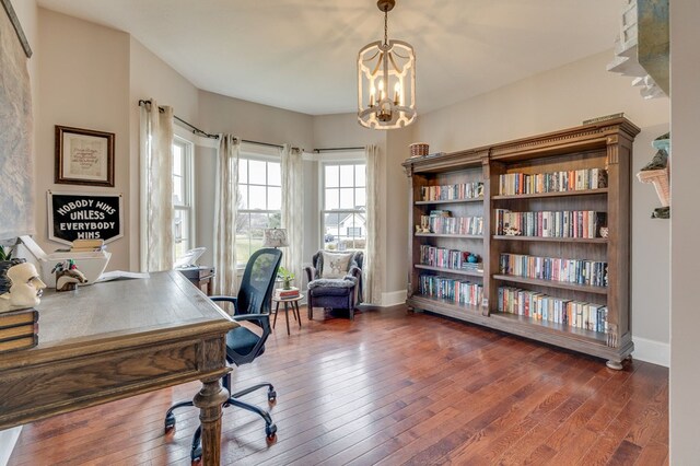 office featuring hardwood / wood-style floors, an inviting chandelier, and baseboards