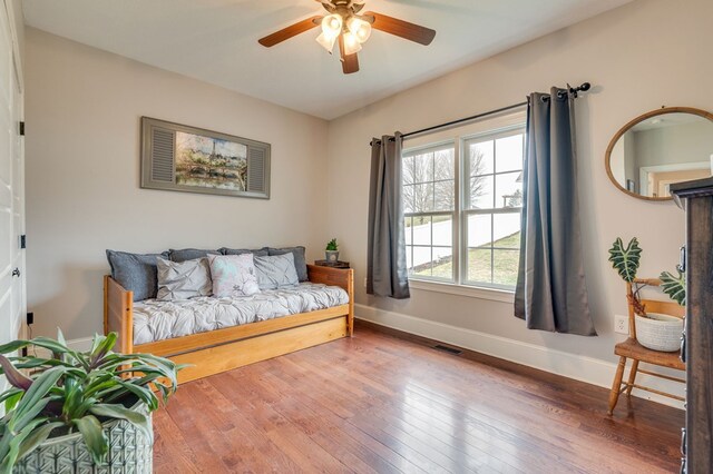 interior space with visible vents, ceiling fan, baseboards, and hardwood / wood-style flooring