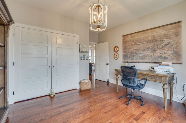 office area featuring baseboards, an inviting chandelier, and wood finished floors