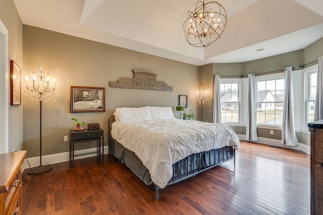 bedroom with baseboards, a notable chandelier, and hardwood / wood-style flooring