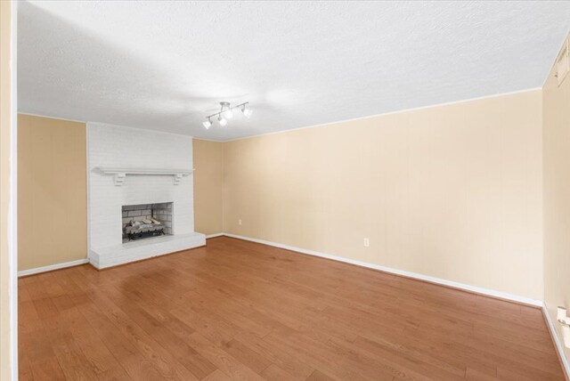 542 Mosswood Ln, Bristol, VA 24201 - unfurnished living room featuring wood finished floors, a textured ceiling, baseboards, and a fireplace