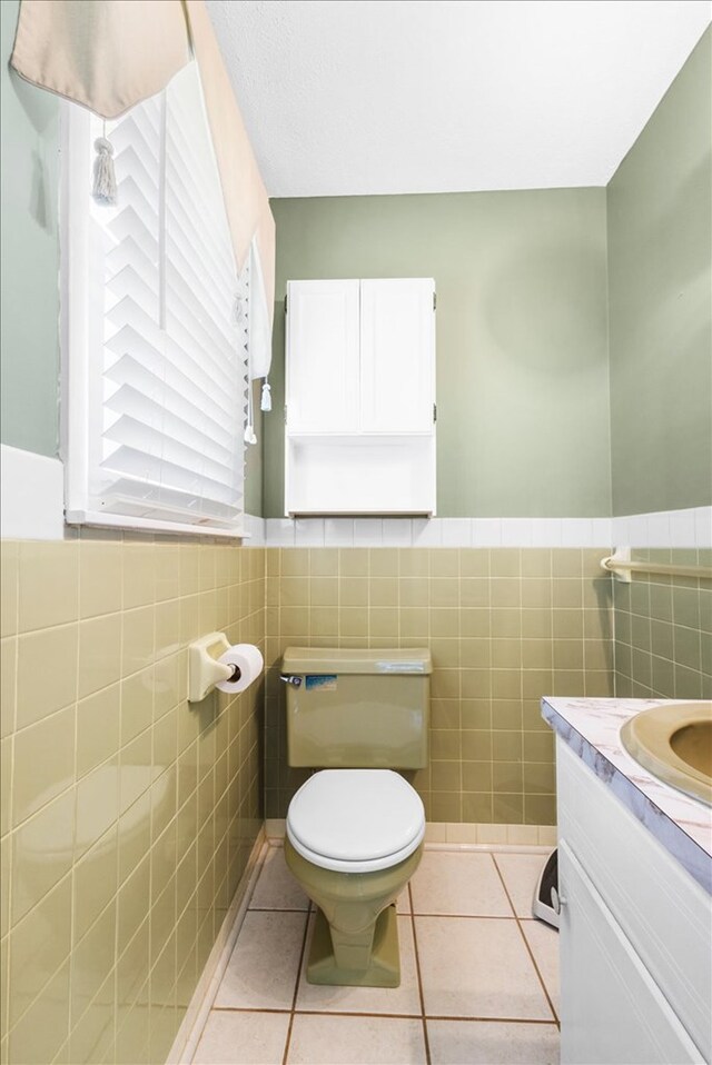 542 Mosswood Ln, Bristol, VA 24201 - half bath with tile walls, tile patterned flooring, toilet, a wainscoted wall, and vanity