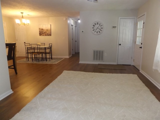 foyer with a notable chandelier and dark hardwood / wood-style floors