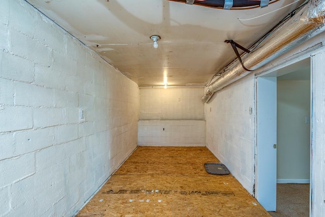 unfinished basement featuring concrete block wall
