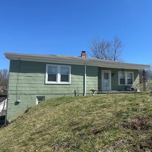 view of front of house with a chimney and a front yard