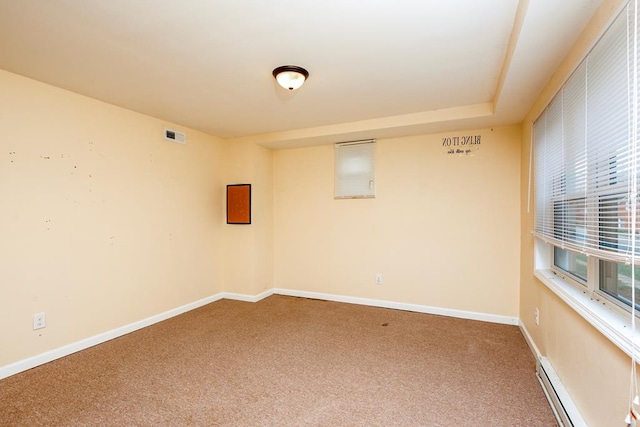 spare room with baseboards, carpet flooring, and a baseboard radiator