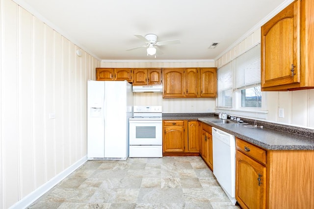 kitchen with brown cabinets, dark countertops, under cabinet range hood, and white appliances