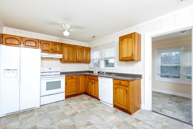 kitchen with brown cabinets, plenty of natural light, under cabinet range hood, dark countertops, and white appliances