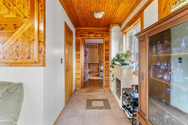 hall with wood ceiling, wooden walls, and baseboards