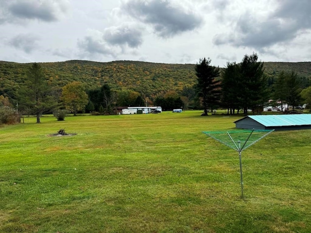 surrounding community with a lawn and a view of trees