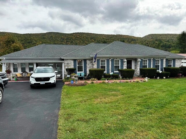 ranch-style home with a mountain view and a front lawn