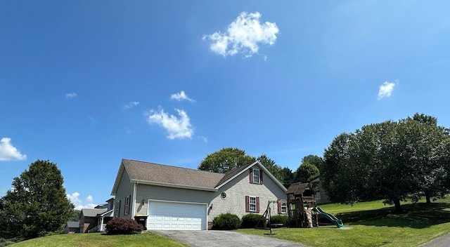 view of front of property with a garage, a front yard, and a playground