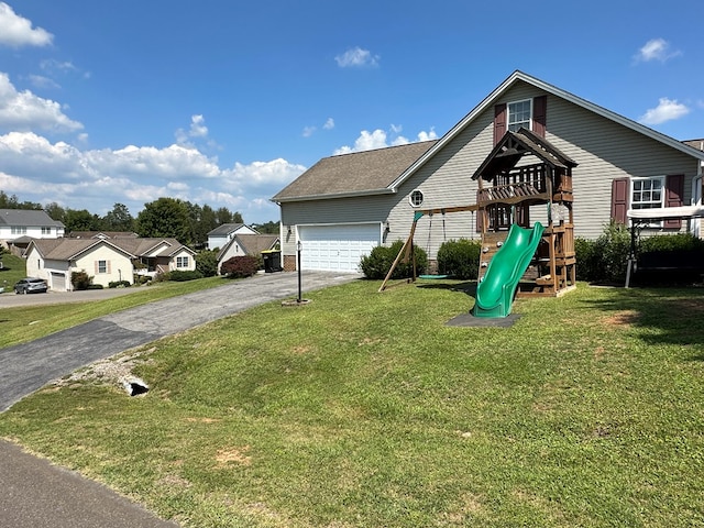 exterior space featuring a playground, a garage, and a front yard