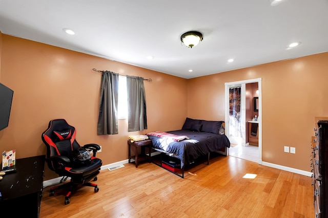 bedroom featuring ensuite bathroom and light hardwood / wood-style flooring