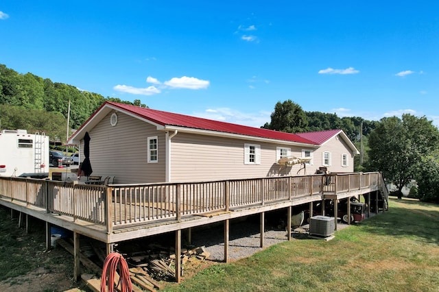 rear view of property featuring a wooden deck, a yard, and central AC unit