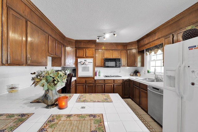 kitchen featuring sink, tile countertops, black appliances, a textured ceiling, and backsplash