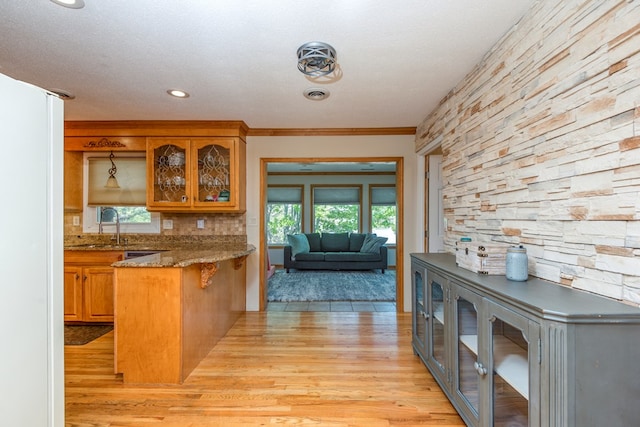 515 Meadowcrest Dr, Bristol, VA 24201 - kitchen with brown cabinets, a sink, a peninsula, glass insert cabinets, and light wood-style flooring