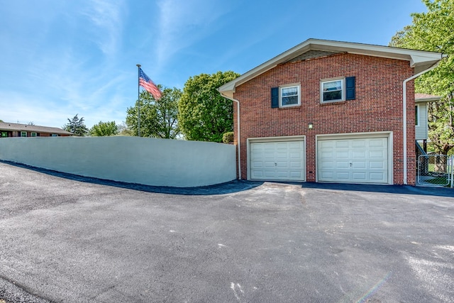 515 Meadowcrest Dr, Bristol, VA 24201 - view of side of home with brick siding, an attached garage, aphalt driveway, and fence