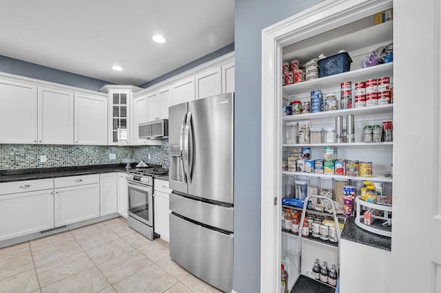 567 Saint James Rd, Chilhowie, VA 24319 - kitchen with stainless steel appliances, light tile patterned flooring, white cabinets, tasteful backsplash, and glass insert cabinets