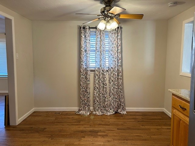 unfurnished dining area with dark wood-type flooring and ceiling fan