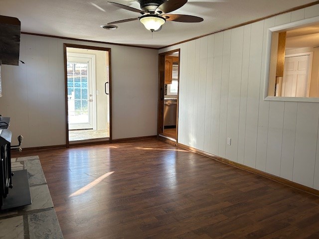 empty room featuring crown molding, ceiling fan, and dark hardwood / wood-style floors