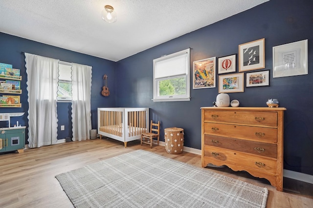 16050 Industrial Park Rd, Bristol, VA 24202 - bedroom with wood finished floors, a nursery area, and a textured ceiling