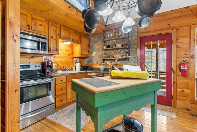 799 Crystal Springs Dr, Fancy Gap, VA 24328 - kitchen featuring appliances with stainless steel finishes, light wood-style flooring, a sink, wooden walls, and open shelves