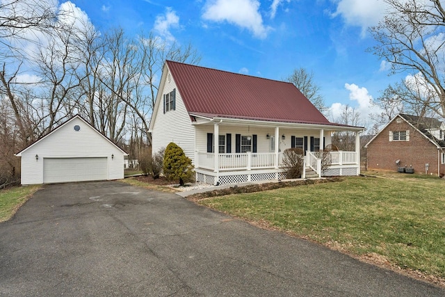 view of front facade with an outbuilding, a detached garage, a porch, a front yard, and metal roof