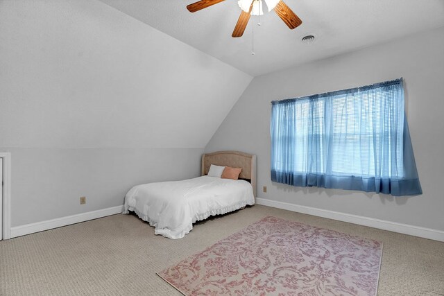 carpeted bedroom featuring visible vents, ceiling fan, baseboards, and lofted ceiling