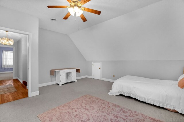 bedroom with carpet flooring, ceiling fan with notable chandelier, baseboards, and lofted ceiling