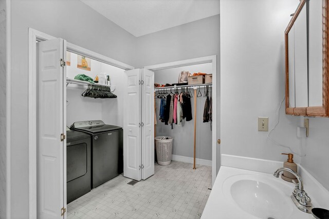 bathroom with tile patterned floors, washing machine and dryer, and a sink