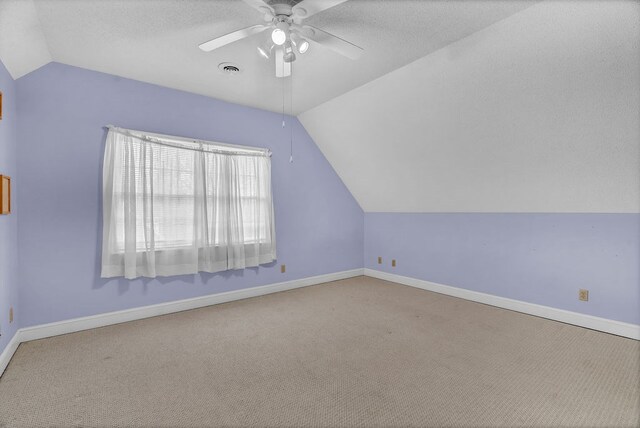 bonus room featuring baseboards, lofted ceiling, ceiling fan, and carpet flooring