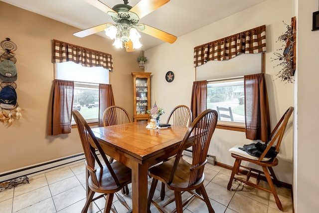 dining space featuring a baseboard radiator, a ceiling fan, light tile patterned floors, and baseboards