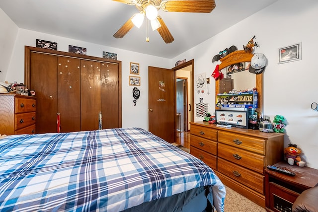 carpeted bedroom with a ceiling fan and a closet