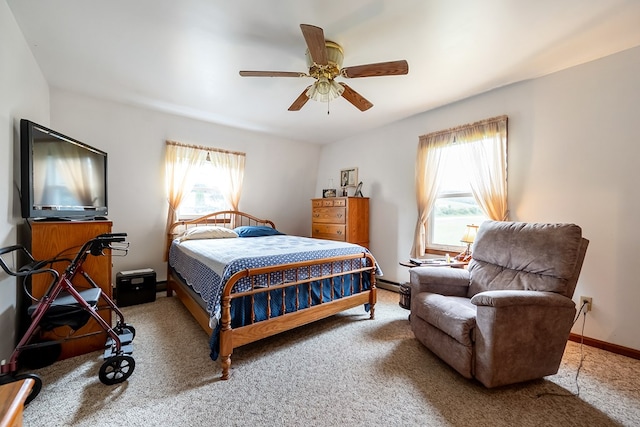 bedroom with carpet, baseboards, multiple windows, and ceiling fan