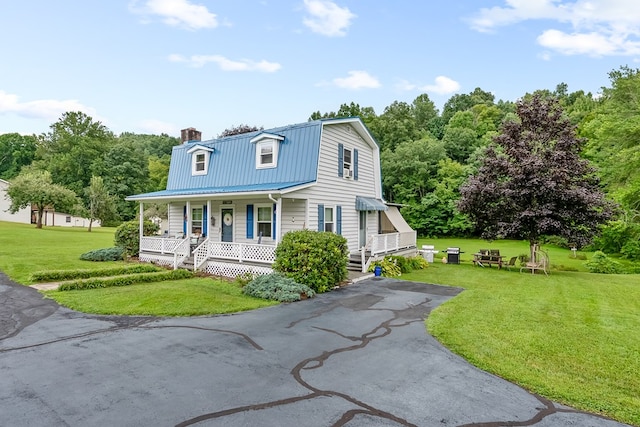 dutch colonial featuring a porch, metal roof, a gambrel roof, and a front yard