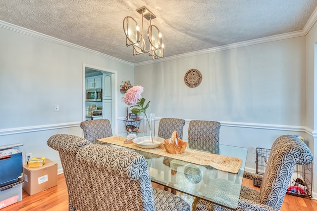 17031 Sedona Dr, Abingdon, VA 24211 - dining space featuring wood finished floors, a chandelier, a textured ceiling, and ornamental molding
