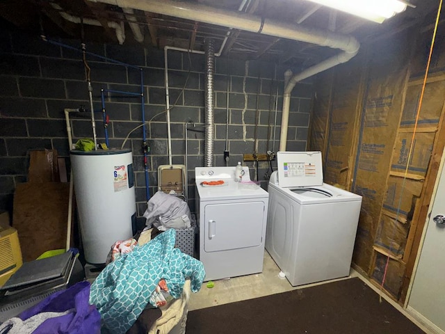 clothes washing area with concrete block wall, water heater, independent washer and dryer, and laundry area