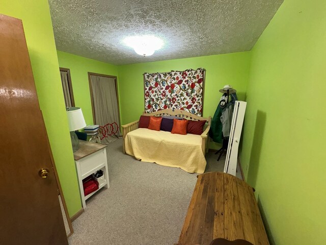 bedroom featuring a textured ceiling and carpet flooring