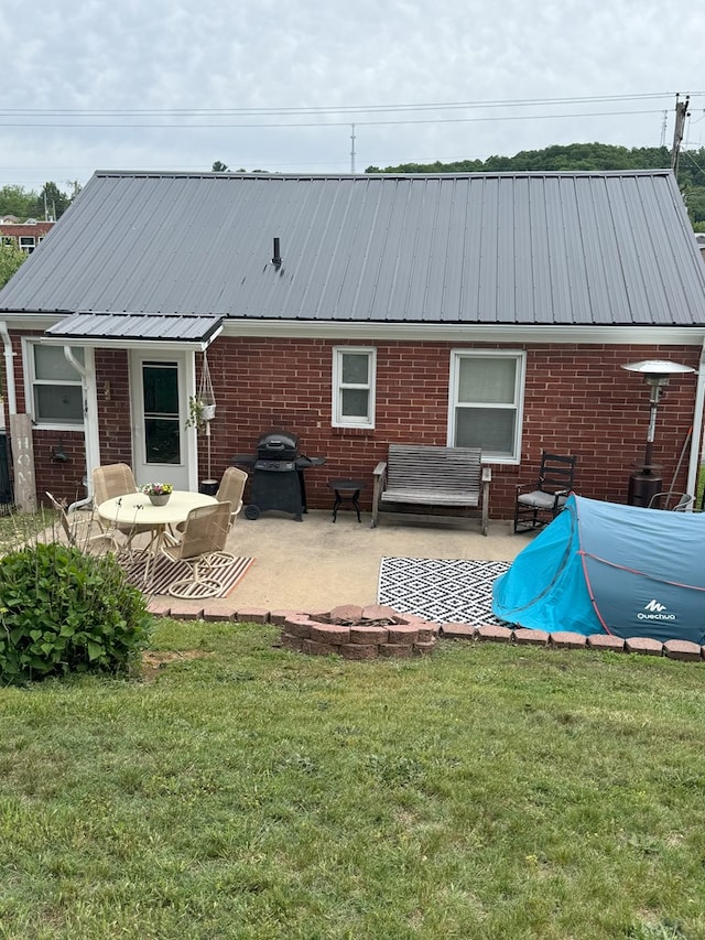 1317 Newton St, Bristol, VA 24201 - rear view of house with brick siding, a patio, a lawn, and a metal roof