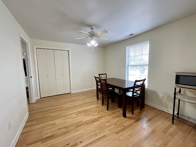 dining area with baseboards, visible vents, light wood-style floors, and ceiling fan