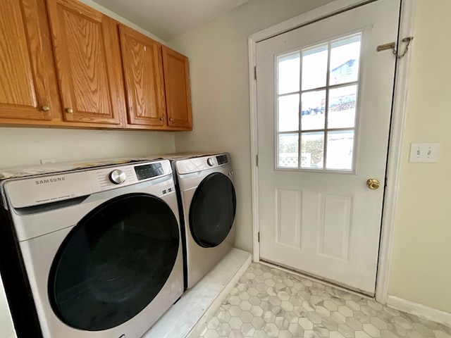 laundry room with cabinet space, baseboards, and separate washer and dryer