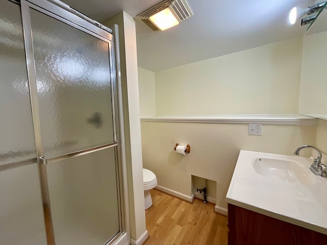 bathroom with wood finished floors, vanity, a shower stall, and visible vents