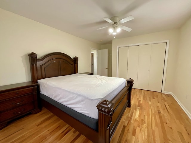 bedroom with a closet, baseboards, light wood-style floors, and ceiling fan