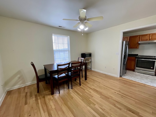 dining space with a ceiling fan, visible vents, baseboards, and light wood-type flooring