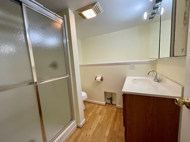 full bath with a shower stall, visible vents, wood finished floors, and vanity