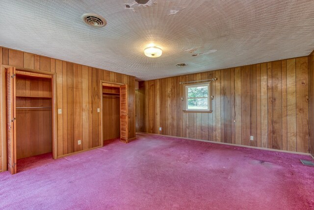 324 Mill Creek Rd, Chilhowie, VA 24319 - unfurnished bedroom featuring wooden walls, visible vents, multiple closets, and carpet floors