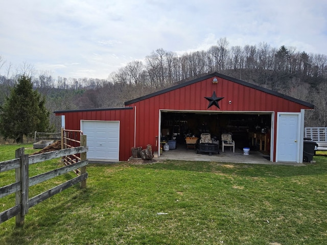 view of pole building with a lawn and fence