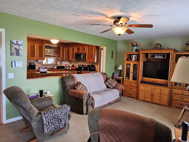 living area with light carpet, ceiling fan, and a textured ceiling
