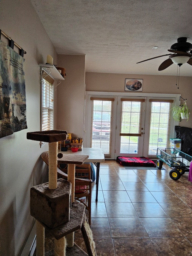 dining space featuring ceiling fan and a textured ceiling